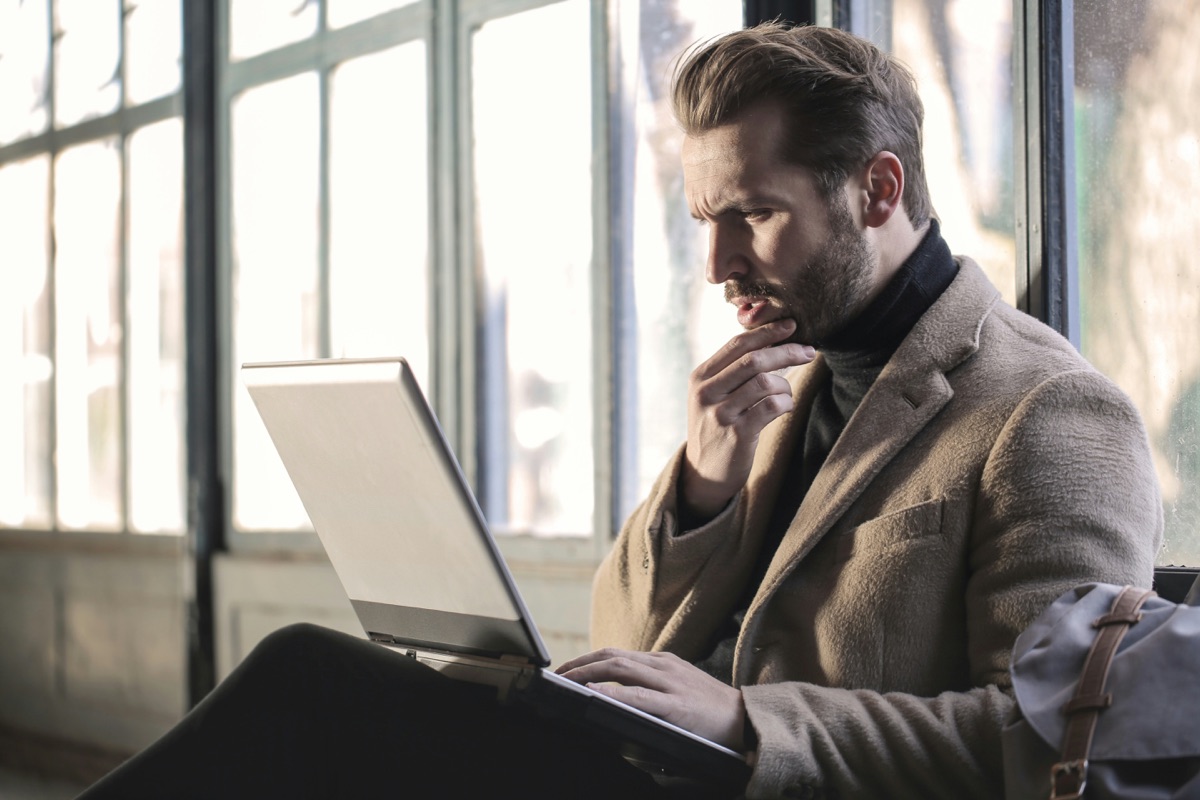 Someone pausing to think while working at a laptop